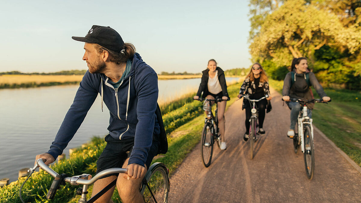 Symbolbild ©Till_Junker Eine Gruppe Radfahrer*innen auf dem Treidelpfad am Flüsschen Ryck.