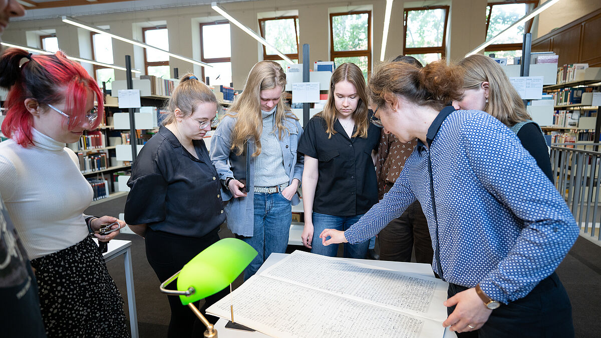 Verena Liu und Gruppe Studierender in der Bibliothek