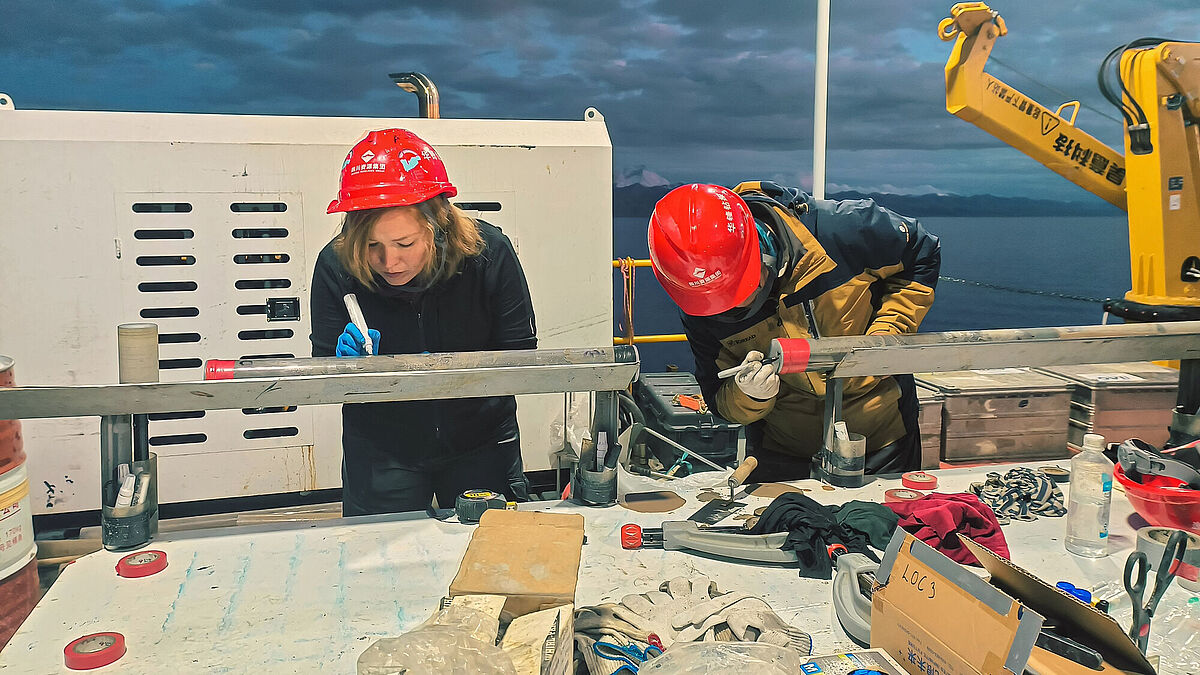 Bevor die Sedimentkerne aus dem Nam Co See in den Laboren analysiert werden können, werden sie an Bord der Bohrplattform gesäubert und beschriftet. 