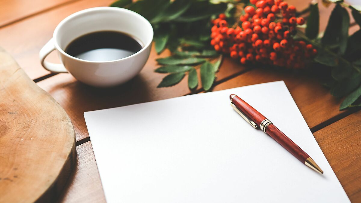 blank paper with pen and coffee cup on wood table @pexels.com